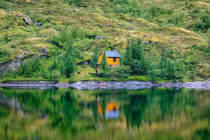 Tablou Canvas, "Coliba singuratică din pădurea verde", Cabana, Mal, Lac, Reflecție, Pădure, Verde, Singurătate, Tranquilitate, Peisaj, Natură, 150 x 100 cm – poza 2