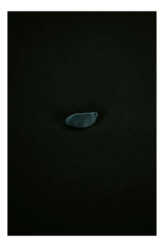 Tablou Canvas, "Piatra solitară în întuneric profund", Piatra, Singurătate, Minimalism, Întuneric, Contrast, Mister, Natură, Simplitate, 26 x 39 cm