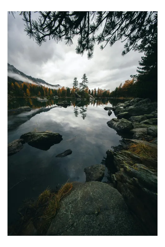 Tablou Canvas, "Reflecția liniștită a toamnei nordice", Lac, Reflecție, Brazi, Nori, Toamnă, Stânci, Peisaj, Serenitate, Natură, Apă, Răgaz, Pini, Munți, Melancolie, Frunziș, 39 x 54 cm