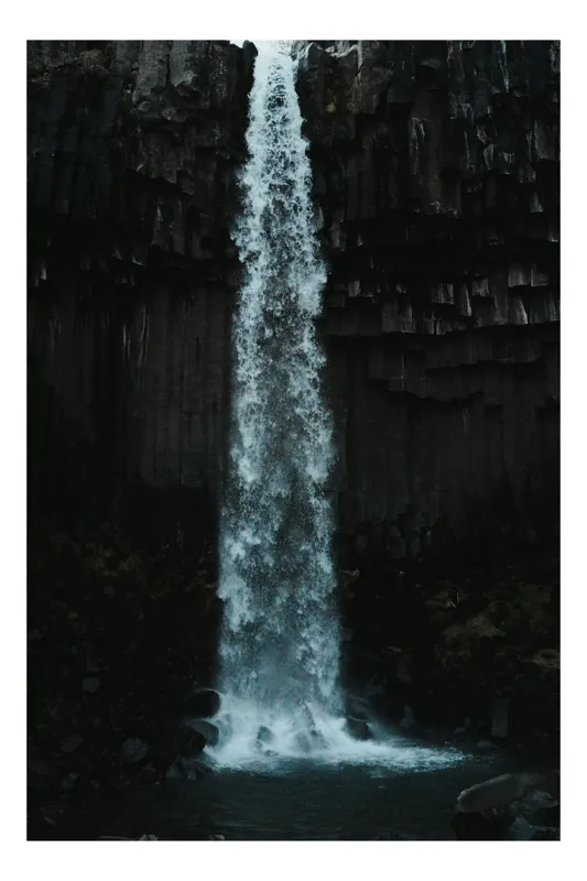 Tablou Canvas, "Cascada în mijlocul stâncilor întunecate", Cascadă, Rocă, Apă, Natură, Spectaculos, Întunecat, Misterios, Coloană, Impresionant, Sălbatic, Relaxant, Putere, 39 x 54 cm