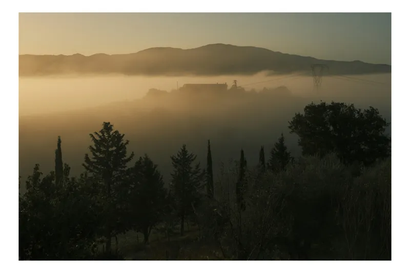 Tablou Canvas, "Mănăstirea învăluită în ceață misterioasă", Ceață, Dimineață, Siluete, Munți, Copaci, Peisaj, Răsărit, Lumină, Mister, Tranquilitate., 70 x 50 cm