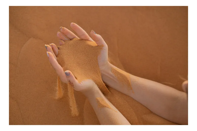 Tablou Canvas, "Timpul se scurge printre degete", Nisip, Mâini, Curgere, Deșert, Textură, Timp, Efemer, Granule, 100 x 70 cm