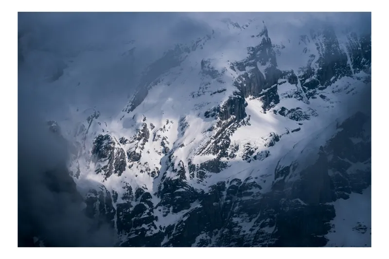 Tablou Canvas, "Strălucirea albă a stâncilor montane", Montan, Înzăpezit, Pătrunzător, Rece, Stâncos, Misterios, Impunător, Noros, 100 x 70 cm