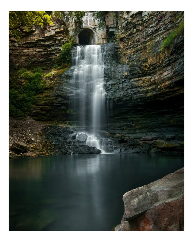 Tablou Canvas, "Cascada ascunsă printre stânci înalte", Cascade, Rocă, Apă, Natură, Vegetație, Lumină, Reflecție, Pădure., 100 x 150 cm