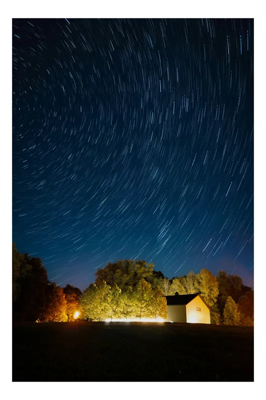 Tablou Canvas, "Stele dansând deasupra casei luminate", Stele, Noapte, Căsuță, Lumină, Cer, Pădure, Timp, Natură, Mișcare, Fotografie, Trasee, Liniște, Claritate, Frumusețe, Împrejurimi, 50 x 50 cm