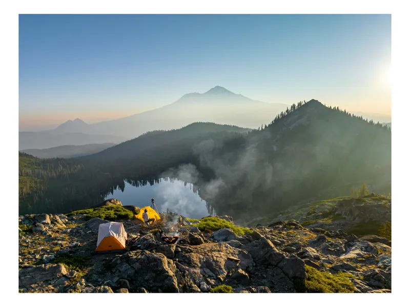 Tablou Canvas, "Tabără pe vârful muntelui liniștit", Tente, Munte, Lac, Răsărit, Ceață, Pădure, Stânci, Aventură, Natură, Cer, Lumină, 100 x 70 cm