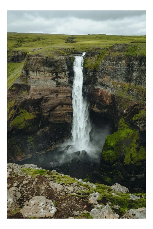 Tablou Canvas, "Cascada în inima naturii verzi", Cascadă, Vale, Roci, Verdeață, Cer, Natura, Peisaj, Dramatic, Limburi, Apă, Ploi, Formidabil, 50 x 70 cm