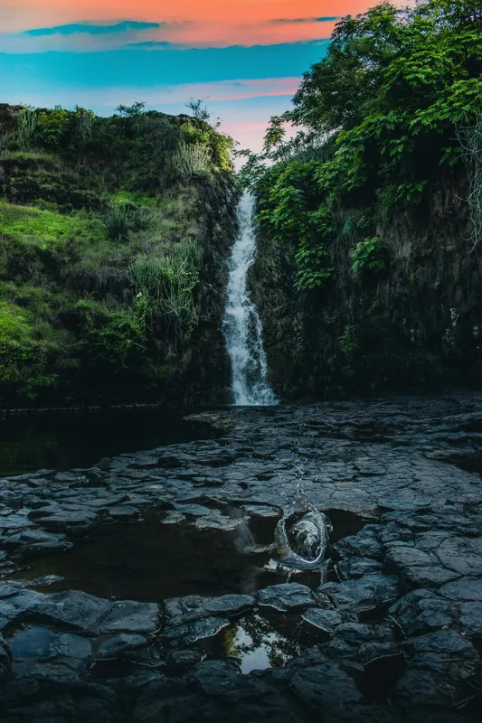 Tablou Canvas, "Cascada în amurgul pădurii tropicale", Apus, Cascadă, Stânci, Vegetație, Apă, Reflecție, Verdeață, Cer, Nori, Natural, Sălbatic, Pitoresc, Peisaj, Tranquil, Frumusețe., 26 x 39 cm – poza 2
