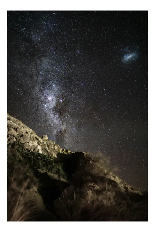 Tablou Canvas, "Calea Lactee deasupra stâncilor iluminată", Stele, Cer, Roci, Univers, Noapte, Peisaj, Galaxie, Mister, Natură, Lumină, 100 x 150 cm