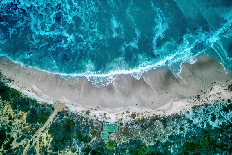 Tablou Canvas, "Valurile albastre la țărmul nisipului", Ocean, Valuri, Plajă, Nisip, Vegetație, Albastru, Argintiu, Natură, Aerian, Peisaj, 150 x 100 cm – poza 2