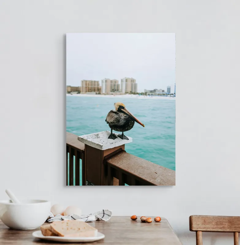 Tablou Canvas, "Pelican așezat pe balustradă la ocean", Pelican, Mare, Balustradă, Clădiri, Cer, Nori, Plajă, Apă, Oraș, Vedere., 50 x 70 cm – poza 3