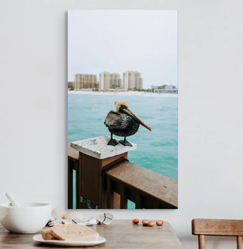 Tablou Canvas, "Pelican așezat pe balustradă la ocean", Pelican, Mare, Balustradă, Clădiri, Cer, Nori, Plajă, Apă, Oraș, Vedere., 50 x 90 cm – poza 3